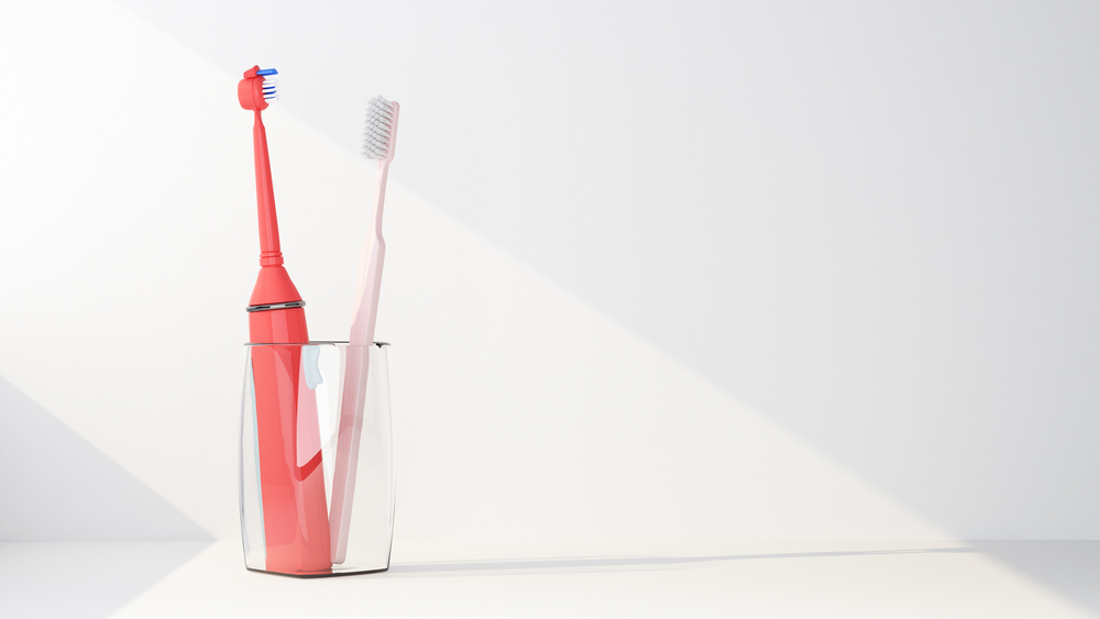 electric and regular toothbrush in one glass