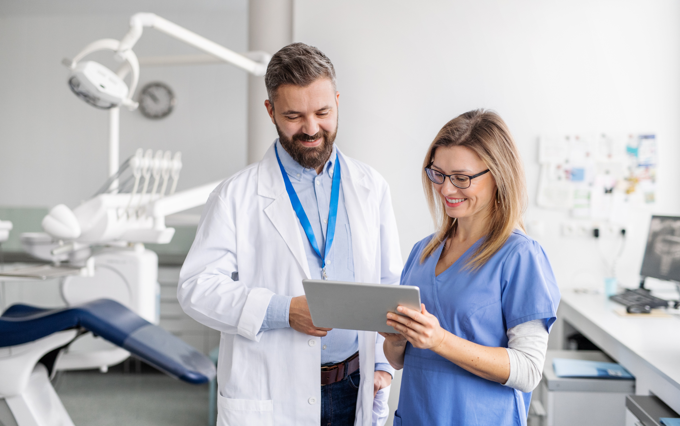 two dentists in a dental office looking at a tablet