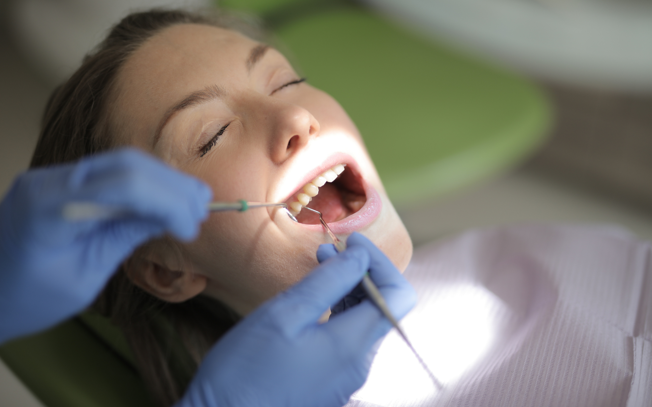 a person is getting their teeth checked by a dentist