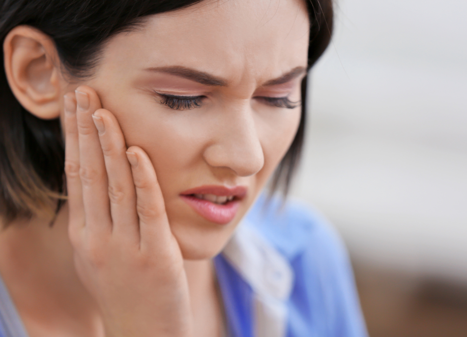 a person has a toothache and is holding their hand to their face