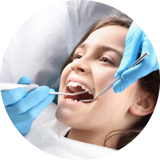 Child receiving a dental exam while a dentist checks her teeth with tools