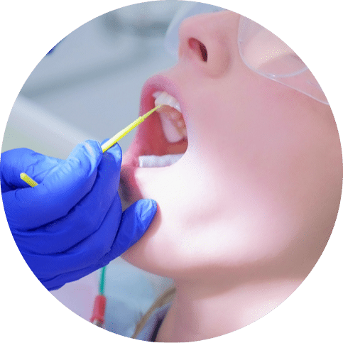 Dental professional applying treatment to a patient’s teeth during a procedure