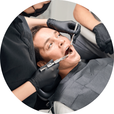 Dentist performing dental treatment with assistant on patient in modern clinic