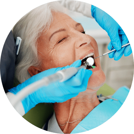 Older woman receiving a dental cleaning with tools during an exam