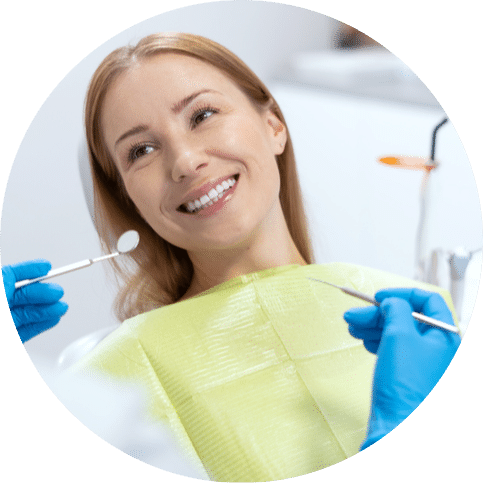 Woman smiling at a dentist while sitting in a chair during a checkup