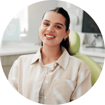 Smiling patient seated in a modern dental treatment room, highlighting a welcoming, comfortable environment and a positive experience before or after a dental appointment.