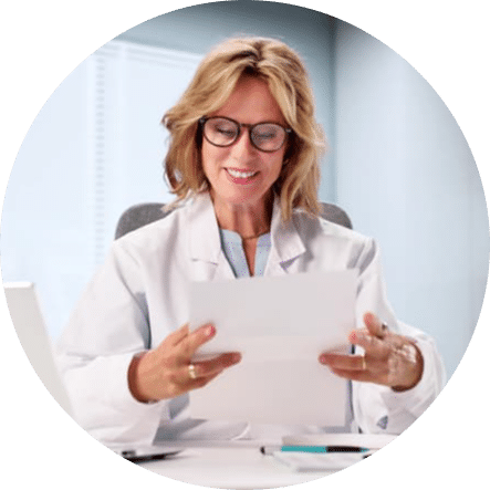 Dental professional reviewing patient records and treatment information on a tablet in a modern clinic, representing personalized treatment planning and coordinated dental care.