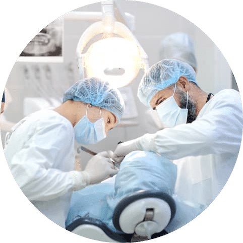Dental team performing an advanced oral procedure on a patient in a clinical treatment room, demonstrating coordinated care, precision, and professional dental expertise.