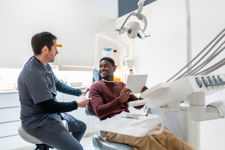 Dentist reviewing treatment options with a smiling patient in a modern dental clinic, emphasizing personalized dental care, clear communication, and a comfortable patient experience.